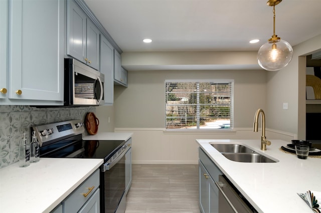 kitchen with appliances with stainless steel finishes, backsplash, decorative light fixtures, and sink