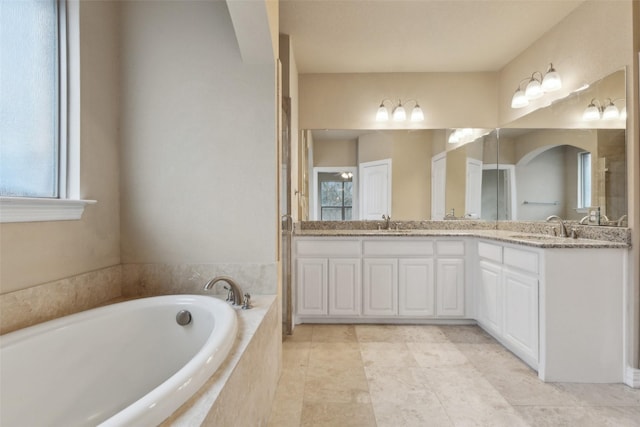 bathroom featuring vanity and a relaxing tiled tub