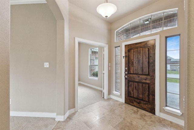 foyer featuring light carpet and a healthy amount of sunlight