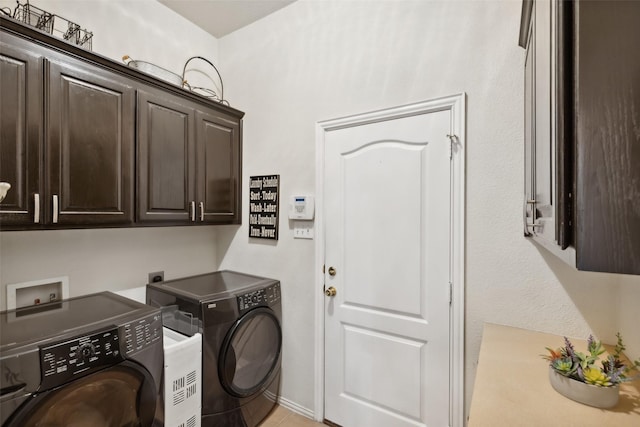 laundry room featuring washer and clothes dryer and cabinets