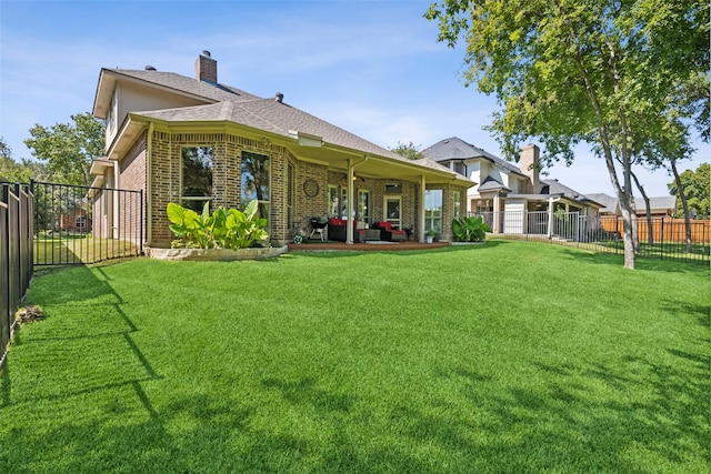 back of property featuring a lawn and a patio