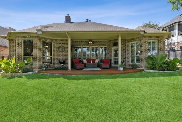 back of property with an outdoor living space and a lawn