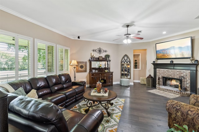 living room featuring dark wood-type flooring, ceiling fan, a fireplace, and ornamental molding