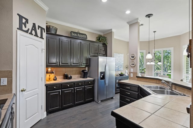 kitchen with tile counters, decorative light fixtures, dark hardwood / wood-style floors, stainless steel fridge with ice dispenser, and crown molding