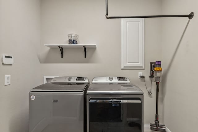 clothes washing area with cabinets and washer and clothes dryer