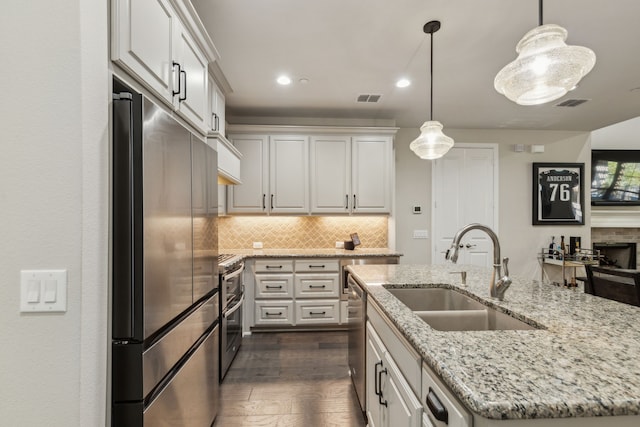 kitchen with white cabinets, sink, stainless steel appliances, and a center island with sink