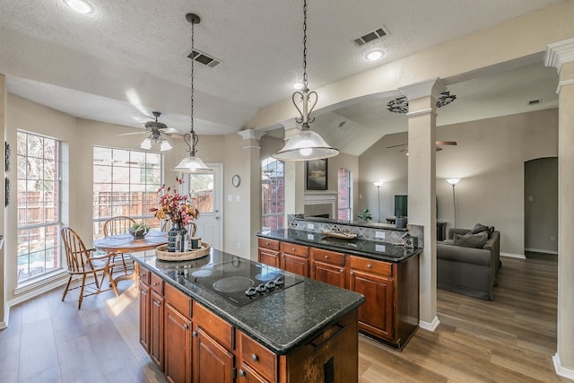 kitchen with ceiling fan, black electric cooktop, a textured ceiling, and a kitchen island