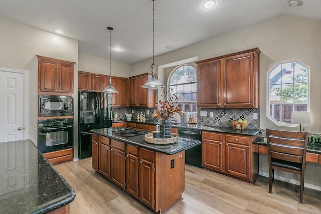 kitchen with pendant lighting, black appliances, a kitchen island, backsplash, and light wood-type flooring