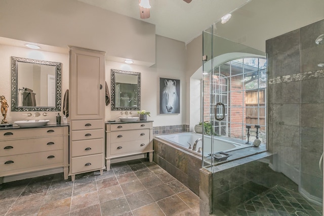 bathroom with ceiling fan, tiled bath, and vanity