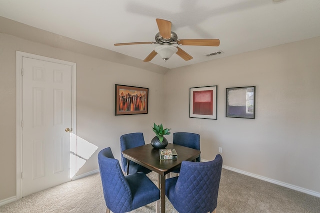 carpeted dining space with ceiling fan