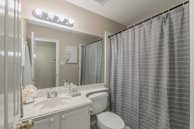 bathroom with toilet, vanity, and a textured ceiling