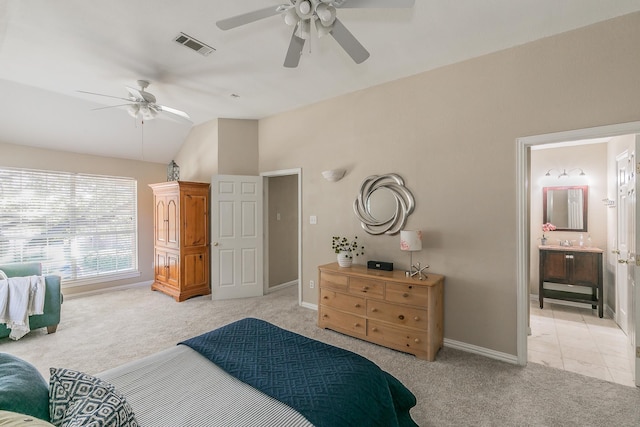 bedroom featuring ceiling fan, light colored carpet, sink, and ensuite bathroom