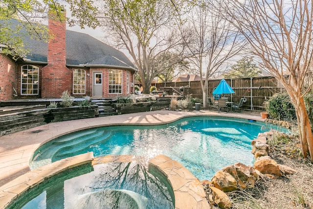 view of pool featuring a patio area and an in ground hot tub