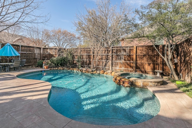 view of swimming pool featuring a patio area and an in ground hot tub