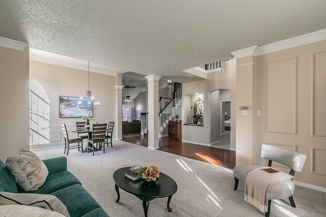 carpeted living room with a textured ceiling, ornamental molding, and a notable chandelier