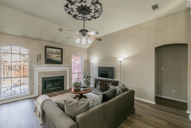 living room featuring dark wood-type flooring, plenty of natural light, and a tile fireplace