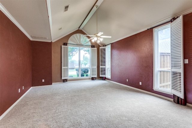 carpeted empty room featuring crown molding, ceiling fan, a healthy amount of sunlight, and lofted ceiling with beams