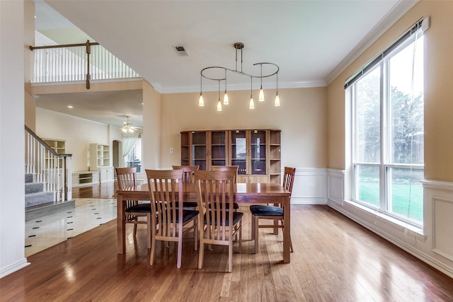 dining room with ceiling fan, ornamental molding, and hardwood / wood-style floors