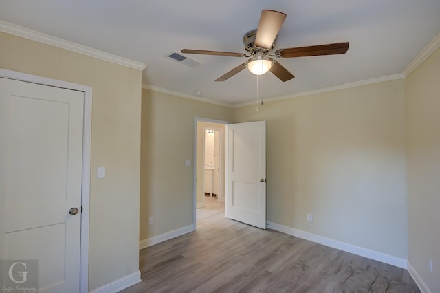 empty room with ceiling fan, ornamental molding, and light wood-type flooring