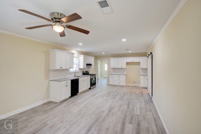 kitchen with a barn door, stainless steel range with gas cooktop, black dishwasher, white cabinets, and sink