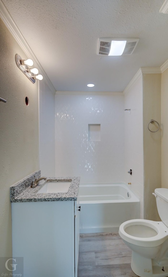 bathroom featuring toilet, hardwood / wood-style flooring, a textured ceiling, ornamental molding, and vanity