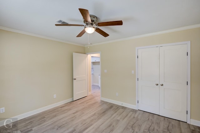 unfurnished bedroom featuring ceiling fan, ornamental molding, a closet, and light hardwood / wood-style floors