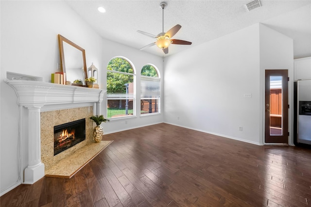 unfurnished living room featuring a textured ceiling, ceiling fan, a high end fireplace, and dark hardwood / wood-style flooring