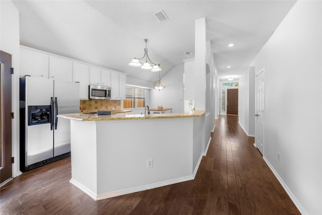 kitchen featuring kitchen peninsula, stainless steel appliances, tasteful backsplash, hanging light fixtures, and white cabinets