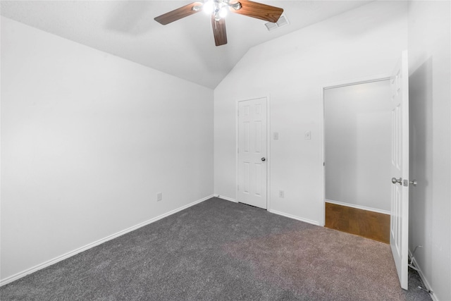 unfurnished bedroom with ceiling fan, lofted ceiling, and dark colored carpet