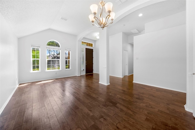 unfurnished living room with lofted ceiling, dark wood-type flooring, a chandelier, and a textured ceiling