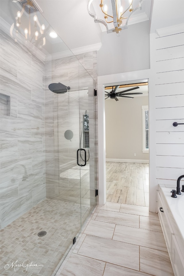 bathroom with plus walk in shower, ornamental molding, and ceiling fan with notable chandelier