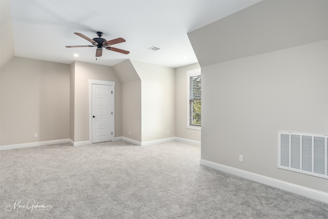 additional living space featuring light carpet, ceiling fan, and lofted ceiling