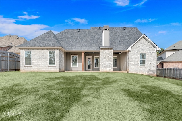 rear view of house featuring a lawn