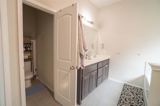 bathroom with tile patterned floors, toilet, double vanity, and a sink