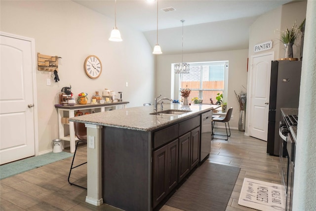 kitchen with visible vents, a sink, stainless steel dishwasher, wood finished floors, and stove