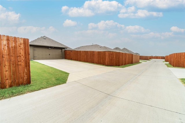 view of home's exterior with a shingled roof, fence, a garage, and a lawn