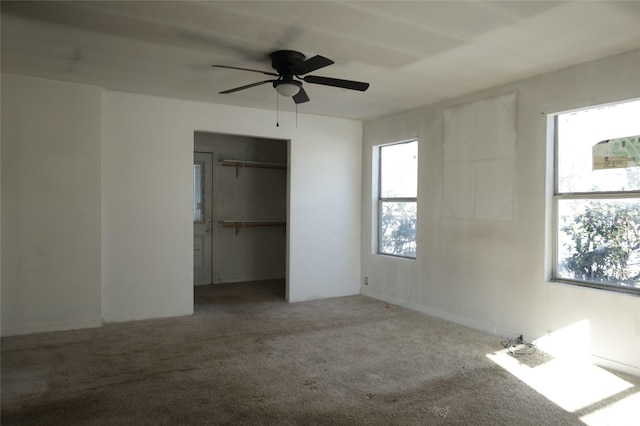 unfurnished bedroom with ceiling fan, a closet, carpet floors, and multiple windows