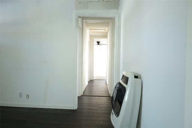 corridor with heating unit and dark hardwood / wood-style floors