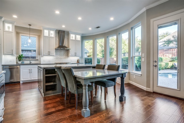 dining room with a wealth of natural light, dark wood-type flooring, sink, and crown molding