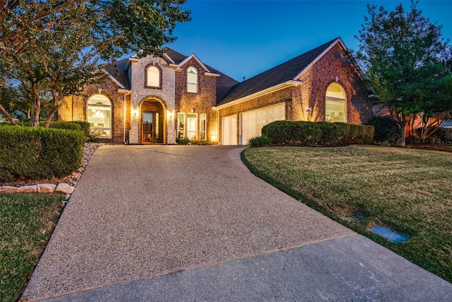 view of front of home featuring a lawn and a garage