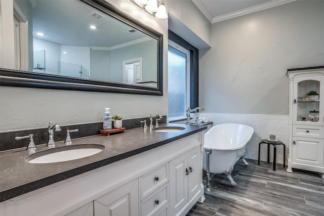 bathroom with vanity, a bathtub, ornamental molding, and hardwood / wood-style floors