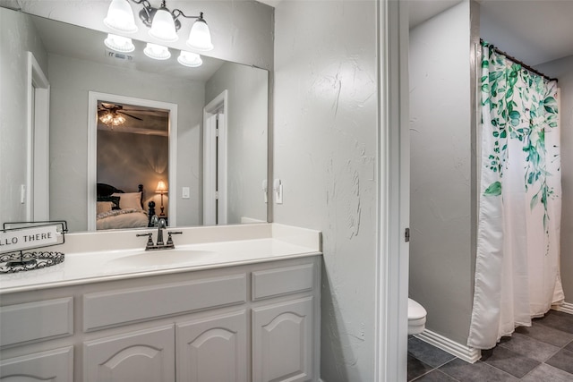 bathroom featuring toilet, ceiling fan, tile patterned flooring, walk in shower, and vanity