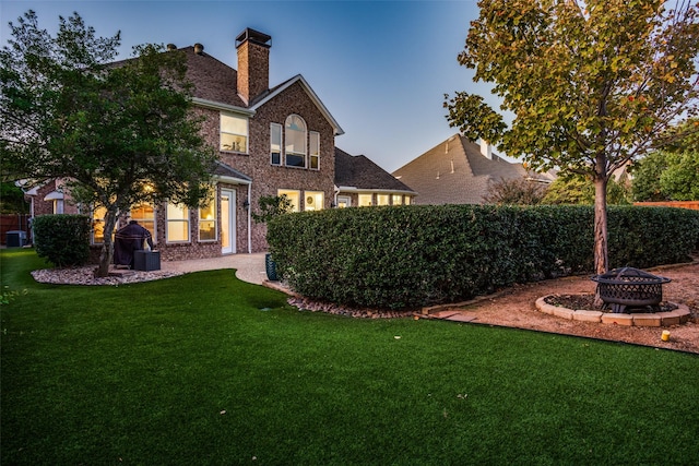 yard at dusk featuring an outdoor fire pit