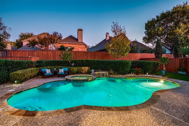 pool at dusk featuring an in ground hot tub