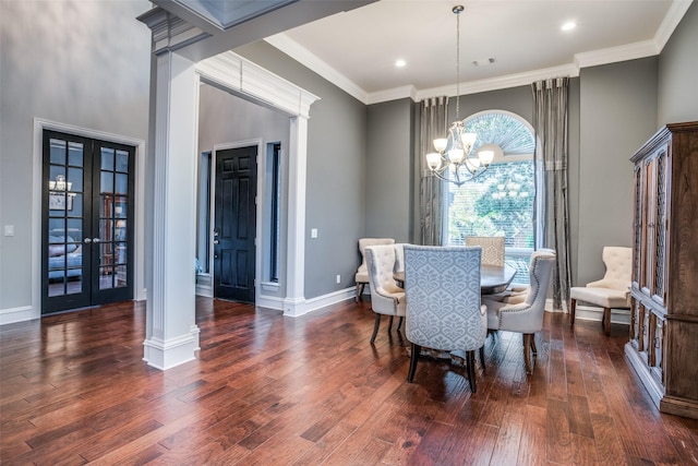 dining room with dark wood-type flooring, french doors, crown molding, and a chandelier