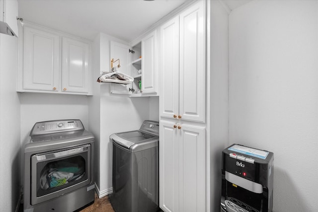 clothes washing area with washing machine and dryer and cabinets