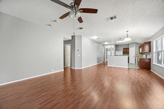 unfurnished living room featuring ceiling fan, a textured ceiling, and hardwood / wood-style floors