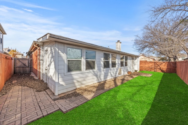 rear view of house with a lawn and a patio