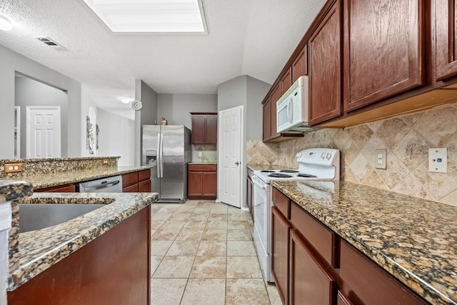 kitchen featuring light tile patterned floors, stainless steel appliances, tasteful backsplash, dark stone countertops, and a textured ceiling