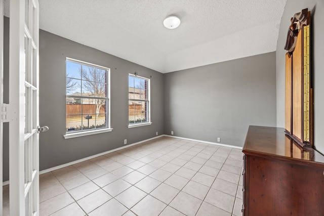 unfurnished room featuring light tile patterned floors and a textured ceiling